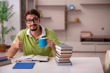 Evde okuyan genç bir erkek öğrenci.