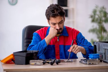 Bilgisayar tamir eden genç bir erkek tamirci.