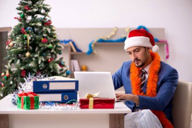 Genç işadamı Noel arifesinde evden çalışıyor.