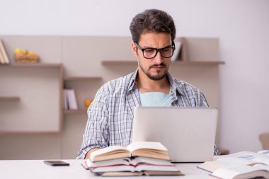 Evde sınava hazırlanan genç bir erkek öğrenci.