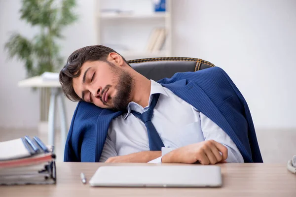 Jovem funcionário masculino extremamente cansado no escritório — Fotografia de Stock