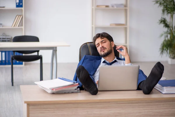 Joven empleado masculino extremadamente cansado en la oficina —  Fotos de Stock