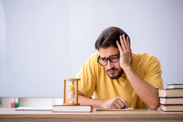 Jonge mannelijke student in time management concept — Stockfoto