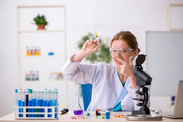 Joven química femenina en concepto de síntesis de fármacos —  Fotos de Stock