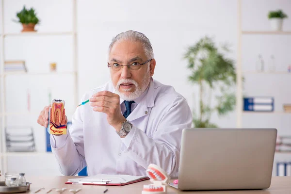 Velho médico dentista trabalhando na clínica — Fotografia de Stock