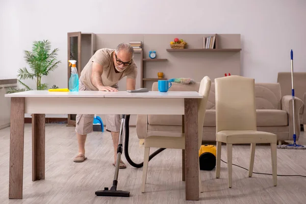 Az öregember házimunkát végez otthon. — Stock Fotó