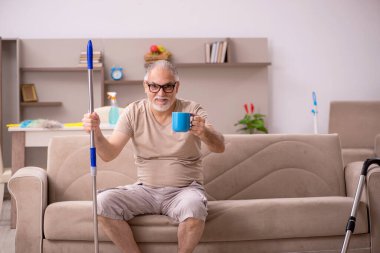 Yaşlı adam evde ev işi yapıyor.