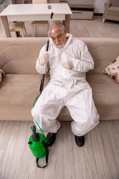 Viejo contratista masculino haciendo control de plagas en casa —  Fotos de Stock