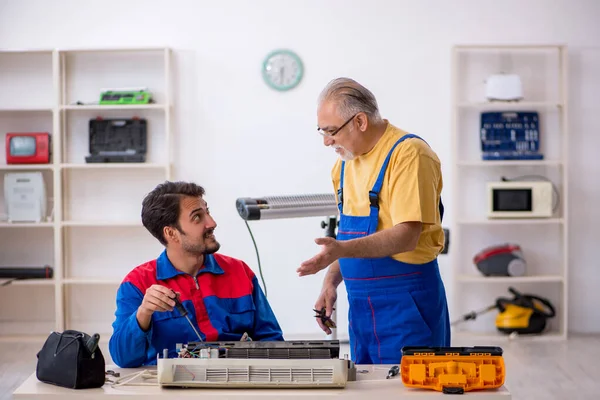 Två manliga reparatörer som reparerar luftkonditioneringen — Stockfoto