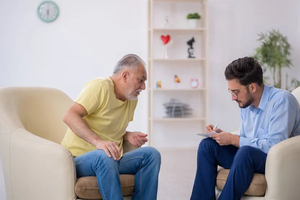 Öreg férfi látogató fiatal férfi pszichoterapeuta — Stock Fotó