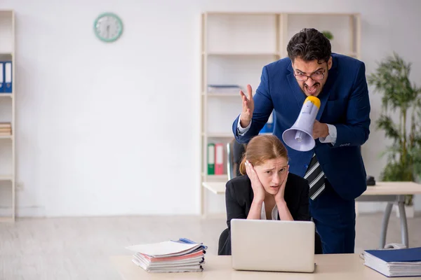 Wütender Chef und junge Mitarbeiterin am Arbeitsplatz — Stockfoto