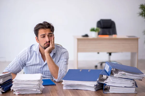 Junge männliche Mitarbeiter und zu viel Arbeit im Büro — Stockfoto