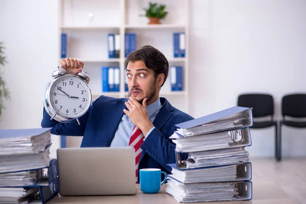 Joven empleado masculino en concepto de gestión del tiempo — Foto de Stock