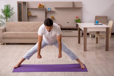 Genç adam evde spor yapıyor.