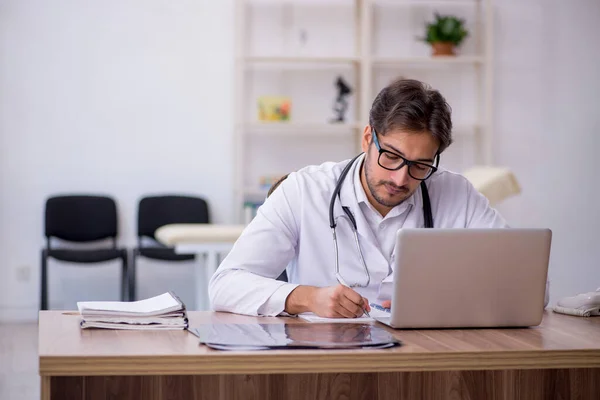 Ung manlig läkare som arbetar på kliniken — Stockfoto