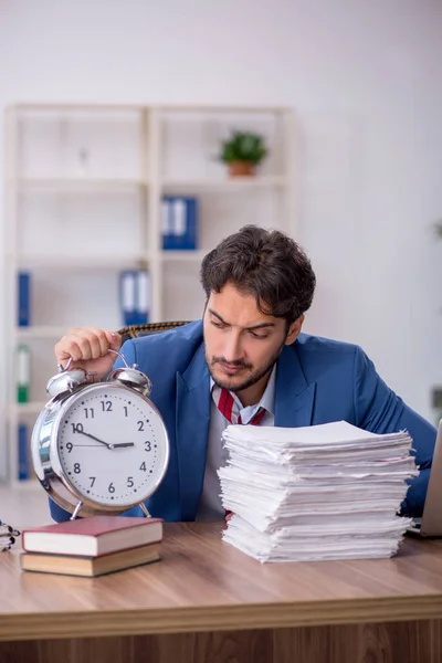 Joven empleado masculino en concepto de gestión del tiempo — Foto de Stock