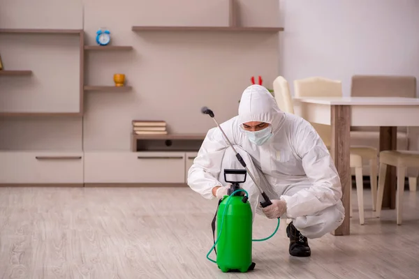 Jovem empreiteiro fazendo controle de pragas em casa — Fotografia de Stock