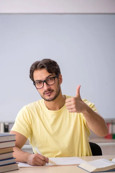 Joven estudiante masculino preparándose para los exámenes en el aula —  Fotos de Stock