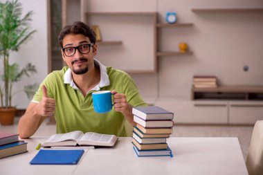 Evde okuyan genç bir erkek öğrenci.