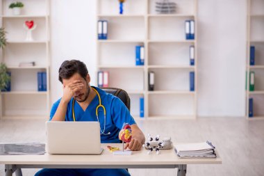 Klinikte çalışan genç erkek doktor.