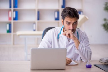 Klinikte çalışan genç erkek doktor.