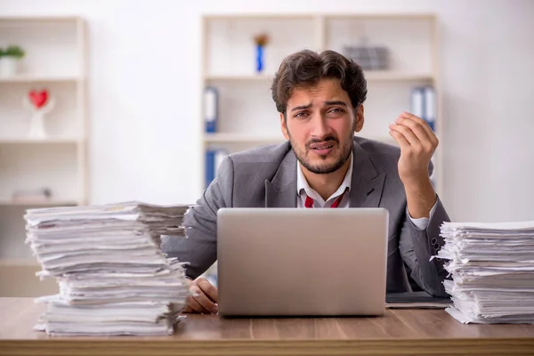 Jovem funcionário masculino infeliz com excesso de trabalho no escritório — Fotografia de Stock