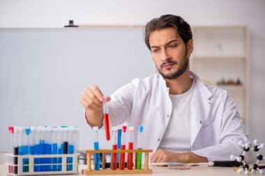 Laboratuvarda çalışan genç bir kimyager.