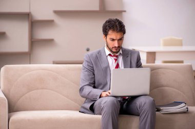 Genç erkek çalışan salgın sırasında evden çalışıyor.