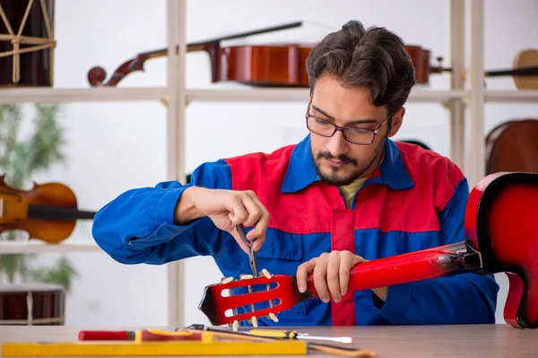 Jovem reparando instrumentos musicais na oficina — Fotografia de Stock