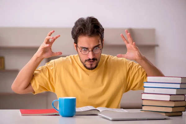 Jonge mannelijke student bereidt zich voor op examens thuis — Stockfoto