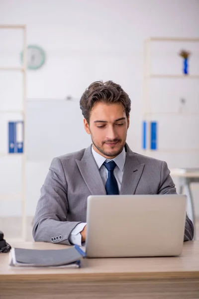 Giovane dipendente maschile seduto sul posto di lavoro — Foto Stock