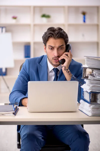 Jeune employé masculin et trop de travail au bureau — Photo