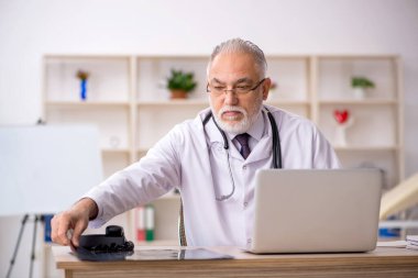 Klinikte çalışan yaşlı bir erkek radyolog.