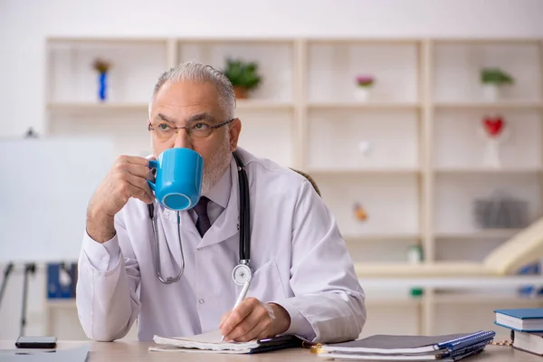 Velho médico do sexo masculino trabalhando na clínica — Fotografia de Stock