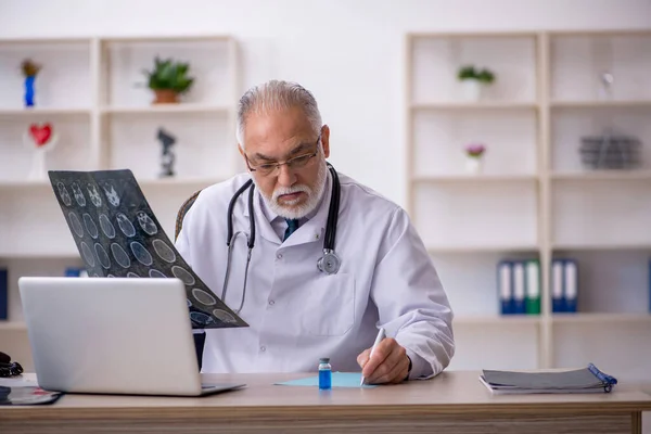 Klinikte çalışan yaşlı bir erkek radyolog. — Stok fotoğraf