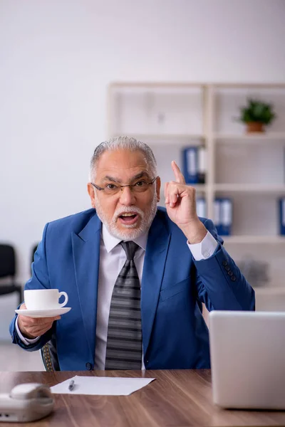 Vecchio dipendente maschio bere caffè durante la pausa — Foto Stock