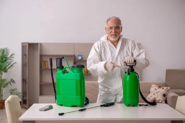 Viejo contratista masculino haciendo control de plagas en casa —  Fotos de Stock