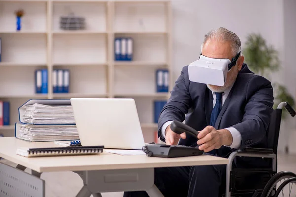 Oude been gewonde mannelijke werknemer met een virtuele bril op workpla — Stockfoto