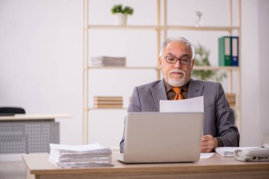 İş yerinde çalışan yaşlı bir erkek işçi.