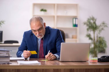 İş yerinde çalışan yaşlı bir erkek işçi.