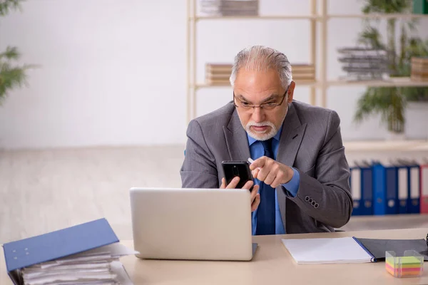 Vecchio dipendente di sesso maschile che lavora sul posto di lavoro — Foto Stock