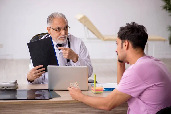 Young male patient visiting old male doctor — Stock Photo, Image