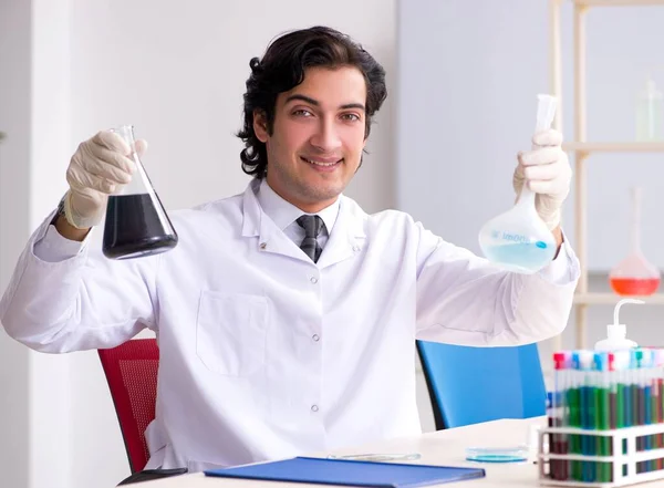 Mladý pohledný chemik pracující v laboratoři — Stock fotografie