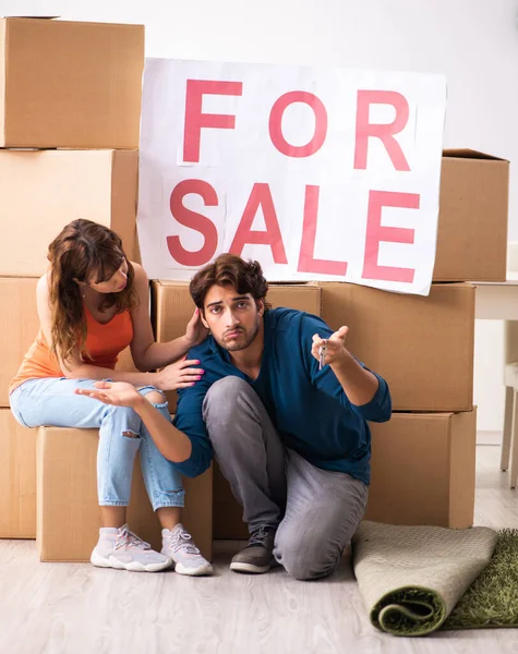 Joven familia ofreciendo casa para la venta y mudanza — Foto de Stock