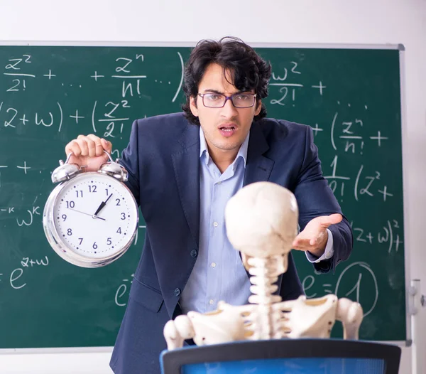 Jovem professor de matemática masculino e esqueleto de estudante — Fotografia de Stock