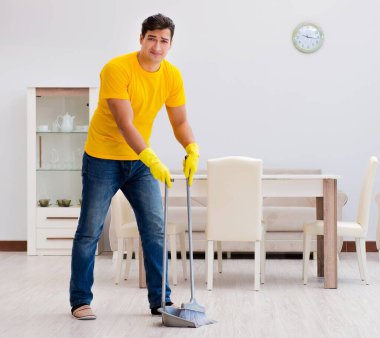 Evi temizleyen adam karısına yardım ediyor.