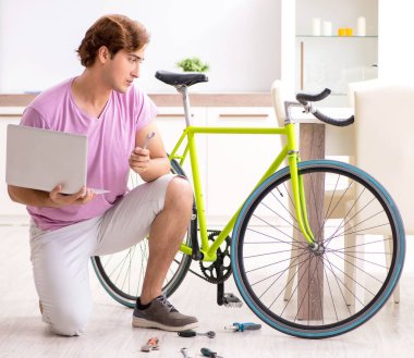 Kırık bisikletini tamir eden adam.