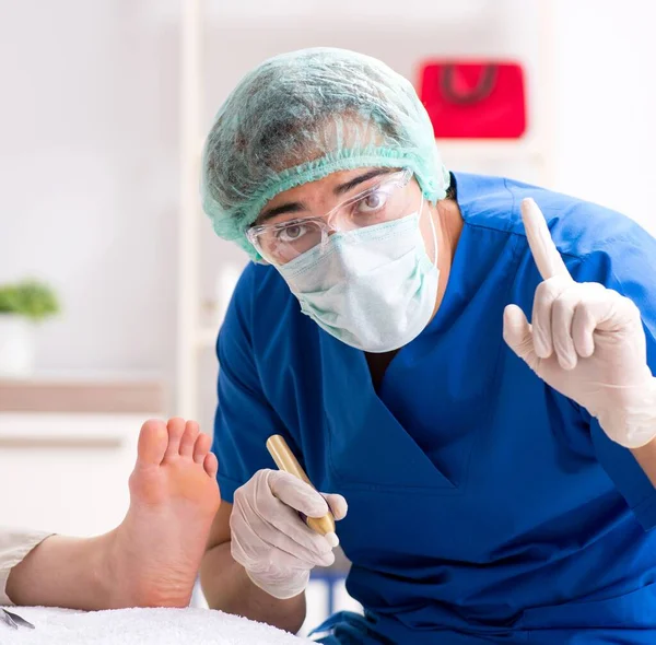 Ортопед лечит стопы во время процедуры — стоковое фото