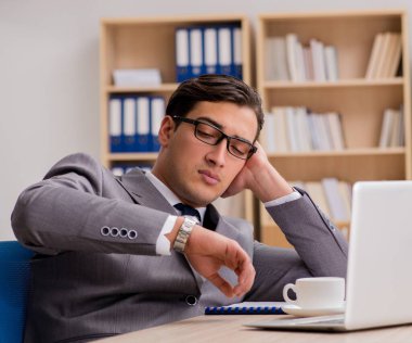 Genç yakışıklı işadamı ofiste çalışıyor.