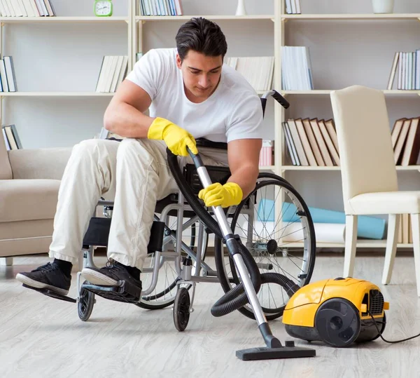 Behinderter Mann mit Staubsauger zu Hause — Stockfoto